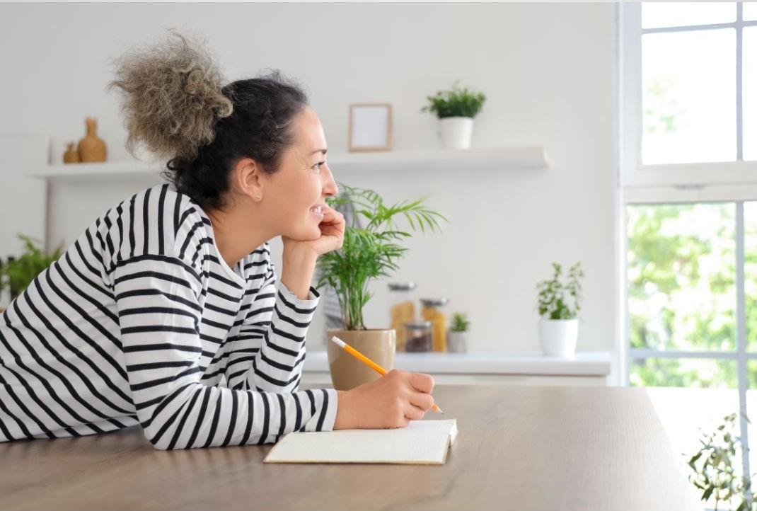 mujer anotando para simplificar su casa